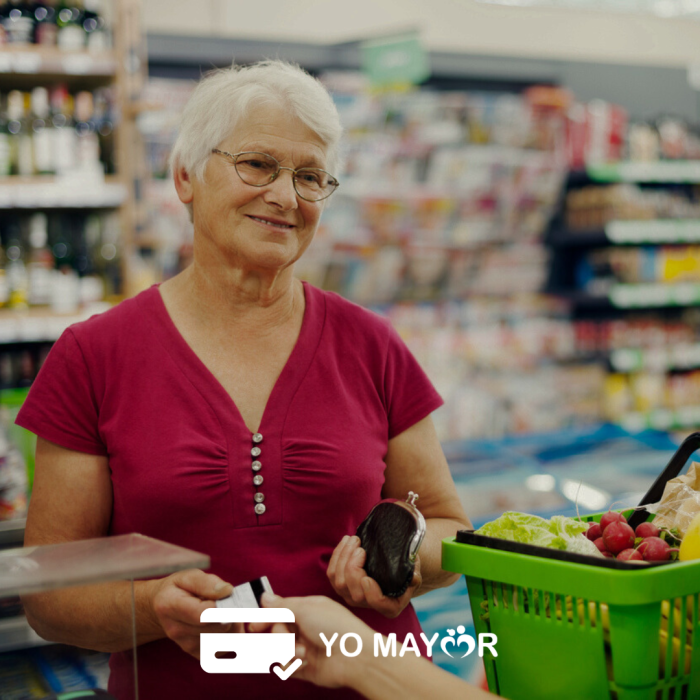 Socia adulta mayor usando su Tarjeta Yo Mayor mientras hace las compras